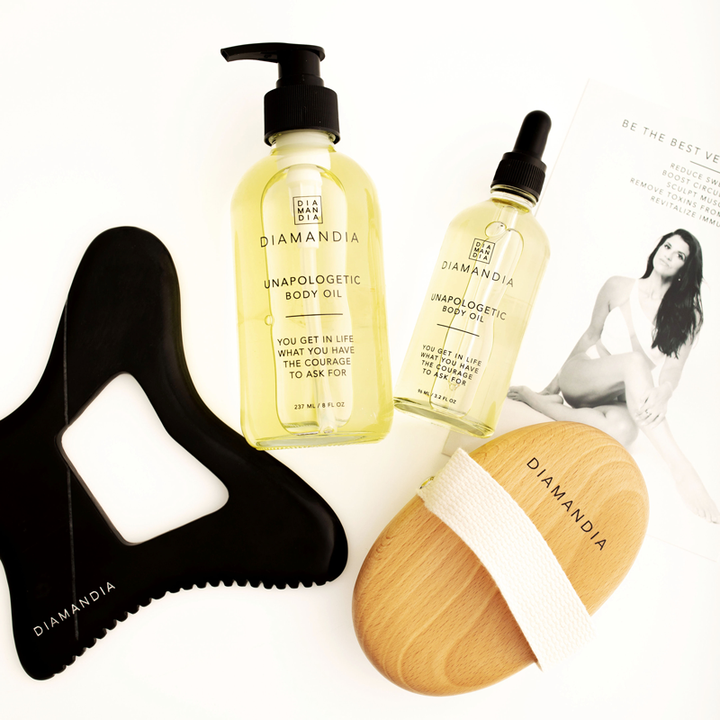 Serene spa setting with Bian stone and stainless steel Gua Sha tools, a glowing bottle of vegan body oil, and soft natural lighting.