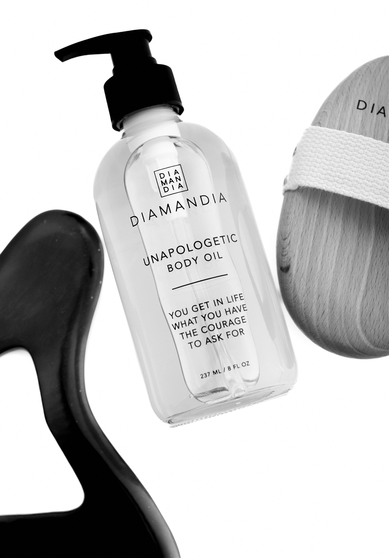 Serene self-care scene featuring Bian stone and stainless steel Gua Sha tools with Unapologetic Body Oil.